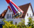 Symbolbild: Uwe Anspach/dpa
Ein Bündel mit Umhüllungen für Glasfaserkabel hängt vor einem Wohnhaus.