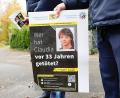 Bild: Daniel Löb/dpa
Ein Polizist mit einem Plakat zum Mordfall von 1990 in Röthenbach an der Pegnitz.