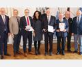 Bild: Regierung der Oberpfalz/Stühlinger-Weinhändler/exb
Regierungspräsident Walter Jonas und Landrat Roland Grillmeier (von links) gratulieren Bernd Sommer (Dritter von links), Hilmar Wollner (Vierter von rechts) und Friedrich Holm (Dritter von rechts) zur Ehrung. Erste Gratulanten waren Bürgermeisterin Margit Bayer aus Waldershof, Bürgermeister Toni Dutz aus Wiesau (Zweiter von rechts) und Zweiter Bürgermeister Karlheinz Hoyer (rechts) aus Waldsassen.