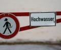 Symbolbild: Andreas Arnold/dpa
Ein Hochwasser-Schild steht an einem überfluteten Feld.