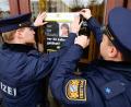 Bild: Daniel Löb/dpa
Polizisten hängen das Plakat zum Cold-Case von Claudia Obermeier an einer Glasscheibe auf.