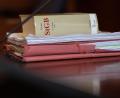 Symbolbild: Swen Pförtner/dpa
Das Strafgesetzbuch und Akten liegen in einem Gerichtssaal auf dem Tisch.