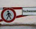 Bild: Andreas Arnold/dpa/Symbolbild
Ein Hochwasser-Schild steht an einem überfluteten Feld.