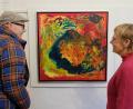 Bild: do
Die Kunstausstellung mit Bildern von Karl Aichinger handelt "Vom Schauen der Schöpfung". Interessiert betrachten Gäste der Vernissage das Bild mit dem Titel "Macht des Schicksals", einem Kunstwerk in Öl und Acryl auf Leinwand