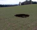 Bild: td
Ein tiefes Loch in einem Feld zwischen Wundsheim und Mitterauerbach lässt die Vermutung zu, dass sich darunter ein Schacht der Grube Max befunden hat, der eingebrochen ist. Die Grube Max gibt es nicht mehr, als letztes Relikt von ihr steht nur noch ein Umspannturm (hinten).