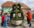 Bild: gi
Die Osterkrone mit ausgeblasenen und handbemalten Hühnereiern auf dem Brunnen am Marktplatz in Moosbach ist wieder ein Schmuckstück, das der Frauenbund gestaltet hat.