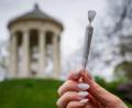 Bild: Peter Kneffel/dpa
Eine Frau hält einen Joint vor der Kulisse des Monopteros im Englischen Garten.