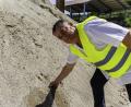Bild: Hösamer
Matthias Schlamminger greift in feinkörnigen Sand: Dieses Material besteht auch aus dem Beton der abgerissenen, Schwandorfer Naabbrücken.