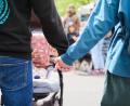 Symbolbild: Annette Riedl/dpa
Eltern halten Händchen, während sie mit ihrem Baby im Kinderwagen über einen Markt gehen.