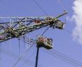 Bild: Hösamer
Arbeit in luftiger Höhe: An einem Mast des Ostbayernrings bei Irrenlohe werden die Leiterseile gezogen. Von der Traverse und der Plattform eines Hubsteigers aus wird in etwa 30 Metern Höhe gearbeitet.