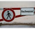 Bild: Andreas Arnold/dpa/Symbolbild
Ein Hochwasser-Schild steht an einem überfluteten Feld.