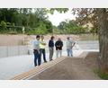 Bild: bey
Ein Blick auf den umgestalteten Pausenhof der Grundschule Luhe-Wildenau. Bürgermeister Sebastian Hartl (links) Schulleiterin Sandra Landgraf (Mitte) und Architekt Josef Schöberl (Zweiter von rechts) sehen sich noch einmal um, bevor die Kinder das Areal in Beschlags nehmen. Im Hintergrund sichtbar die zweistufige Böschungssicherung.