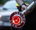 Symbolbild: Paul Zinken/dpa/ZB/
Ein Polizist hält bei einer Verkehrskontrolle eine Kelle in der Hand.