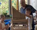 Bild: Michaela Meier/exb
Organist Bernhard Müllers mit zwei Schülern beim Erforschen der kleinen Orgel.
