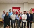 Bild: Martin Schmidberger/exb
Der neue Vorstand der Neustädter SPD. Vorsitzender Sebastian Giering überreicht Lena Groz das rote Parteibuch.