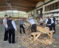 Bild: Michael Kohl/exb
Die Mitglieder des Zimmerervereins Amberg lassen sich in Edelsfeld das traditionelle Behauen von Holzbalken vorführen.