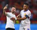 Bild: Tom Weller/dpa
Ein „Flitzer“ ist aufs Spielfeld gelaufen und macht ein Selfie mit Frankreichs Kylian Mbappe (r).