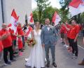 Bild: fvo
Anna-Lena und Simon Bauer schreiten nach der Trauung am Fahrenberg durchs Spalier der Bayernfans Waldthurn.