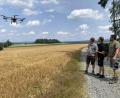Bild: Judith Zeitler/exb
Kevin Weigl, Fabian Rupprecht und Marc Preuß (von links) beobachten den Flug der Drohne. Ohne Bodenverdichtung kann sie Zwischenfrüchte schon vor der Getreideernte aussäen.