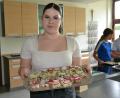 Bild: pz
Selina präsentiert ein Tablett mit belegten Pausenschnitten, die mit Kresse und Radieschen belegt sind. Die Brote hatten Schülerinnen zuvor selbst gebacken.