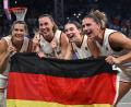 Bild: Sina Schuldt/dpa
Feiern mit der Fahne: Die 3x3-Basketballerinnen.