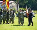 Bild: Bild: US-Armee Garnison Bavaria. 
Director Tommy Mize (recht) übergibt die Truppenfahne von Oberst Kevin Poole an den neuen Kommandeur Oberst Stephen Flanagan als Zeichen des Kommandowechsels.