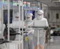 Bild: Robert Michael/dpa
Infineon Mitarbeiter in eine Reinraum. Dem Konzern aus Neubiberg bei München ist ein Durchbruch bei Galliumnitrid gelungen.