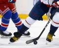 Symbolbild: John Munson/AP/dpa
Zwei Eishockeyspieler kämpfen um den Puck.