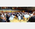 Bild: lg
Das Orchester mit Dirigent Michael Falk und im Hintergrund das konzentrierte Publikum des Jubiläumskonzerts.