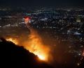 Bild: Ethan Swope/AP/dpa
Ein Hubschrauber wirft Wasser auf das brennende Sunset Fire in den Hollywood Hills.