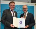 Bild: Staatsministerium für Gesundheit und Pflege/exb
Schulleiter Hans-Jürgen Bruhn (links) freut sich über die Urkunde, die ihm Dr. Rainer Hutka (rechts), Amtschef des Staatsministeriums für Gesundheit und Pflege, überreichte.