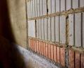 Bild: Gabi Schönberger
Eine Reihe gebrannter Ziegelsteine (rot) soll den Bau künftig vor Nässe von unten schützen.