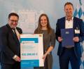 Bild: Wirtschaftsministerium/E.Neureuther/exb
Wirtschaftsstaatssekretär Tobias Gotthard (links) überreicht Regionalmanagerin Veronika Kiener und Sachgebietsleiter Christian Meyer den Förderbescheid.