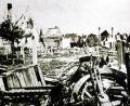 Archivbild: Militärmuseum Grafenwöhr
Nur noch Ruinen und Trümmer beim Blick von der Schönwerthstraße über die Neue Amberger Straße zur Altstadt. Zwischen den linken Giebeln ist der Kirchturm der Maria Himmelfahrtskirche zu erkennen. Nur noch die Außenmauern und Kamine stehen beim Doppelhaus Gebhardt-Knodt, dem Elternhaus von Maria Reiter, geborene Gebhardt (Ruine über dem Motorradlenker).