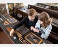 Bild: Stiftlandmuseum/Bewegter Blick/exb
Kinder sind zu einem Mitmachprogramm eingeladen: In der alten Münchenreuther Schule können sie mit Franziska Beck lernen, wie früher mit Tinte, Kreide und Griffel geschrieben wurde.