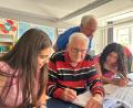 Bild: Veit Wagner, Ak Asyl
Dieter Bock (vorne, Mitte) und sein Kollege Karl-Heinz Schmidkonz (hinten) beantworten ihren Schülerinnen Fragen zu den Mathe- und Physik-Hausaufgaben.