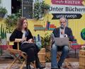 Bild: bl
Kristina Schilke erzählt im Interview mit Jörg Schieke vom MDR auf der Buchmesse in Leipzig von ihrem Faible für magische Elemente und der Herausforderung beim Schreiben von Bettszenen.