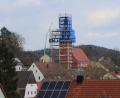 Bild: ds
Umgeben von einer Schutzplane erneuern Fachkräfte die schadhaften Gebälkteile an der Turmspitze von St. Nikolaus in Etzelwang.
