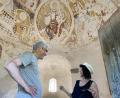 Bild: aub
Initiator und Komponist Joan Riera Robusté mit einer Besucherin seiner Klangillumination zu den zwölf Aposteldarstellungen im Karner in Perschen.