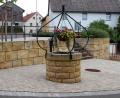 Bild: lep
Der Blick fällt auf den hinteren Bereich des Dorfplatzes in der Mitte der Ortschaft. Der wieder aufgebaute Dorfbrunnen erinnert an die gute alte Zeit, wo hier Wasser entnommen werden konnte. Auf diesem Platz steht der Maibaum und in der Weihnachtszeit ein Christbaum.