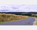 Bild: ubb
Vom Wiesauer Kreuzberg aus gesehen würden Windkraftanlagen das Landschaftsbild im geplanten Vorranggebiet TIR29 erheblich verändern. Links liegt Fuchsmühl, rechts im Tal Triebendorf am Fuße des Teichelbergs. Das dreifach geschützte Naturschutzgebiet liegt weiter rechts und ist nicht direkt betroffen. Jedoch dürfen Windkraftanlagen mit einem Abstand von 500 bis 1000 Metern an geschützte Gebiete heran gebaut werden.