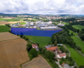 Bild: rw
Um rund sechs Hektar (blaue Fläche) soll das Gewerbegebiet nach Westen erweitert werden. Zwischen dem Inglashof (im Vordergrund) und dem bestehenden Gewerbegebiet liegt in der geplanten Erweiterungsfläche ein Grundstück mit verbrieftem Wasserrecht – zentraler Streitpunkt in der aktuellen Diskussion.