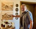 Bild: Gerhard Krones
Hartmut Schendzielorz zeigt auf sein Elternhaus in der ehemaligen Bergwerkssiedlung "Auf der Kolonie", darüber ein Bild mit dem dazugehörigen "Badhaus". Gemalt hat diese Bilder sein Schulfreund Alfred Ollek.