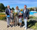 Bild: Andreas Hofmeister/Stadt Schwandorf
Oberbürgermeister Andreas Feller (links) und Bäderleiter Michael Maget (rechts) überreichen Familie Schatz aus Stulln als 100.000. Besucher der Saison eine Familienkarte für 2026.