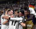 Bild: Federico Gambarini/dpa
Florian Wirtz wird für sein Freistoßtor von den Teamkollegen bejubelt.
