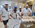 Bild: bl
Juniorchef Vinzenz Paulus (links) und sein Vater Josef Paulus (rechts) setzen in Sachen Personal auf internationale Verstärkung. Komi Amedjonkou (Zweiter von links) und sein Kollege Ekue Kuevidjen (Dritter von links) kommen aus Togo, um hier das Metzger-Handwerk zu erlernen.