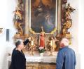 Bild: lg
Maria Hummer, hier mit Ehemann Herbert, und deutet auf Details im Nepomuk-Gemälde, wie beispielsweise die Bergung von Nepomuks Leichnam in der Moldau.