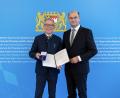 Bild: StMFH/Christian Blaschka
Finanz- und Heimatminister Albert Füracker überreicht das Verdienstkreuz am Bande an Reinhold Wildenauer.