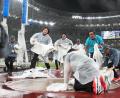 Bild: Michael Kappeler/dpa
Mehrere Helferinnen und Helfer versuchten alles, um den Wurfring vom Regen zu befreien.