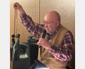 Bild: Erhard Nitzbon
Wie Literflaschen Bier um den Hals gehängt und zum Arbeitsplatz getragen wurden, demonstriert Sepp Lösch bei seiner Lesung über die Geschichte der Maxhütte.